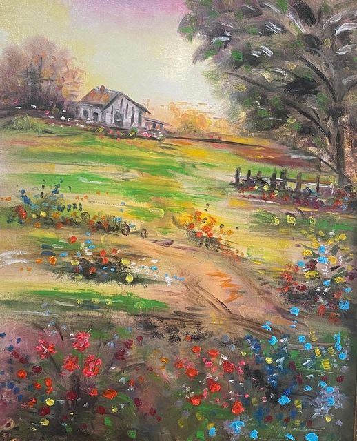 A farmhouse behind a meadow full of wildflowers
